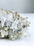 Crystal cluster on a white surface with a gray background