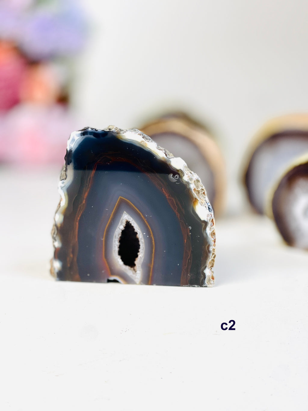 Natural agate geode cut base standing on white table