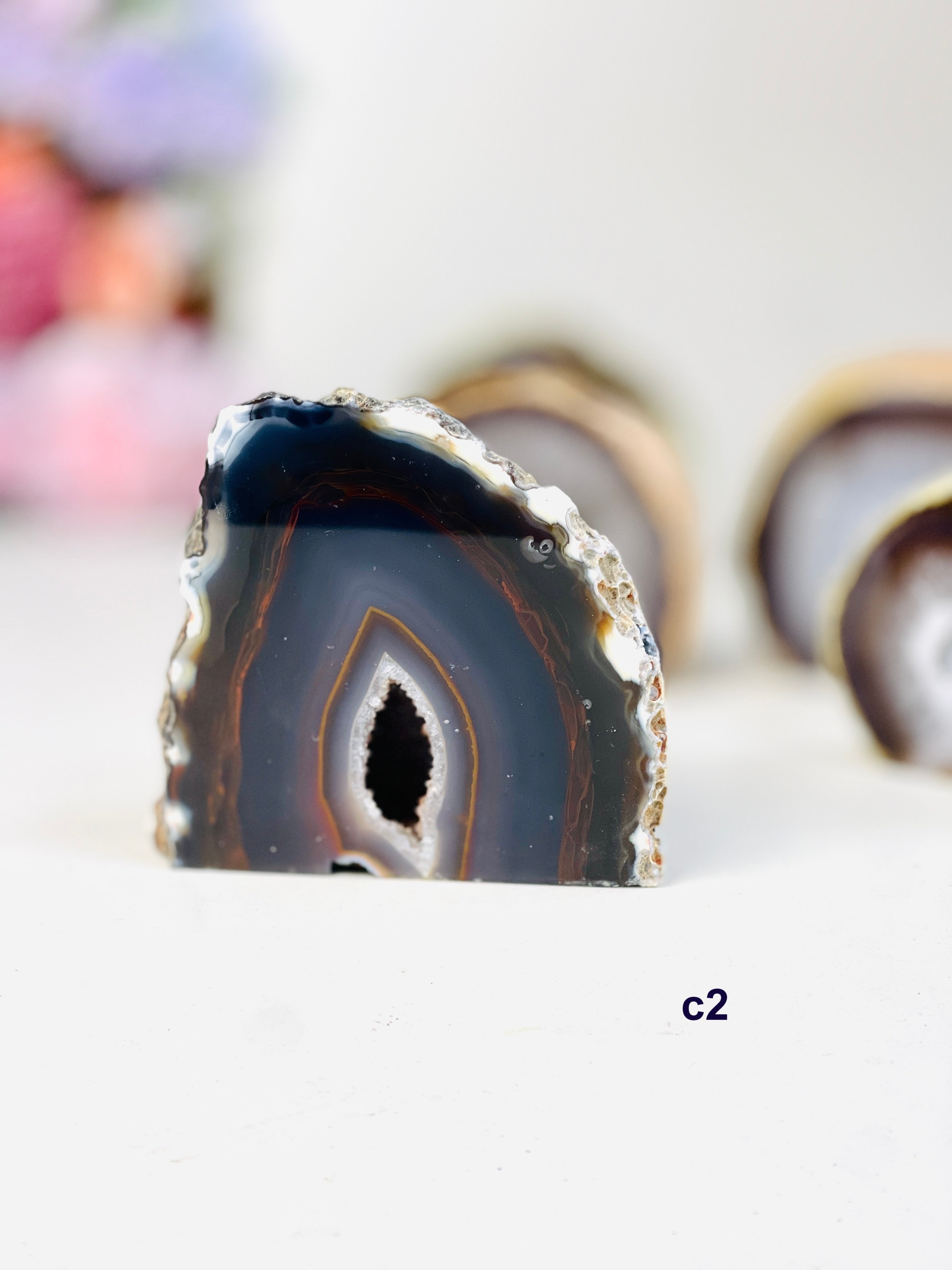 Natural agate geode cut base standing on white table