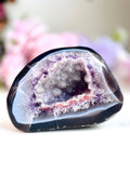 Geode crystal with purple interior on a white background