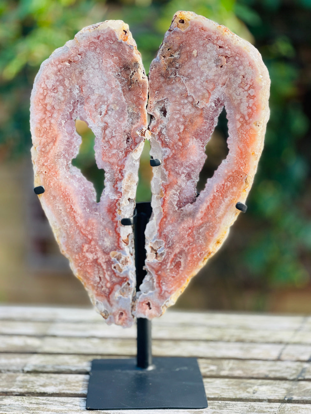Pink Amethyst Wings on a wooden table with blured background