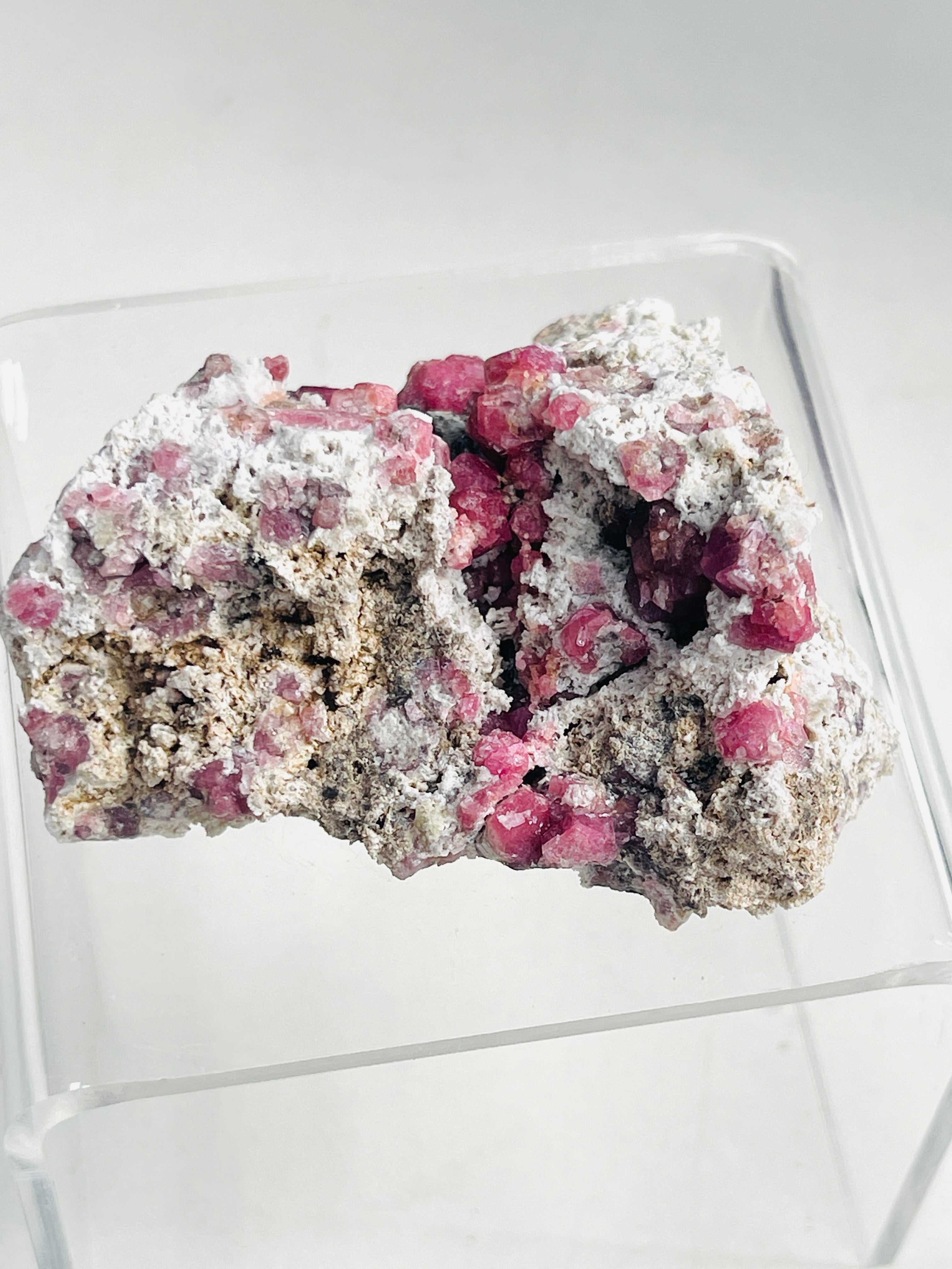 Mineral sample with pink crystals on a white background