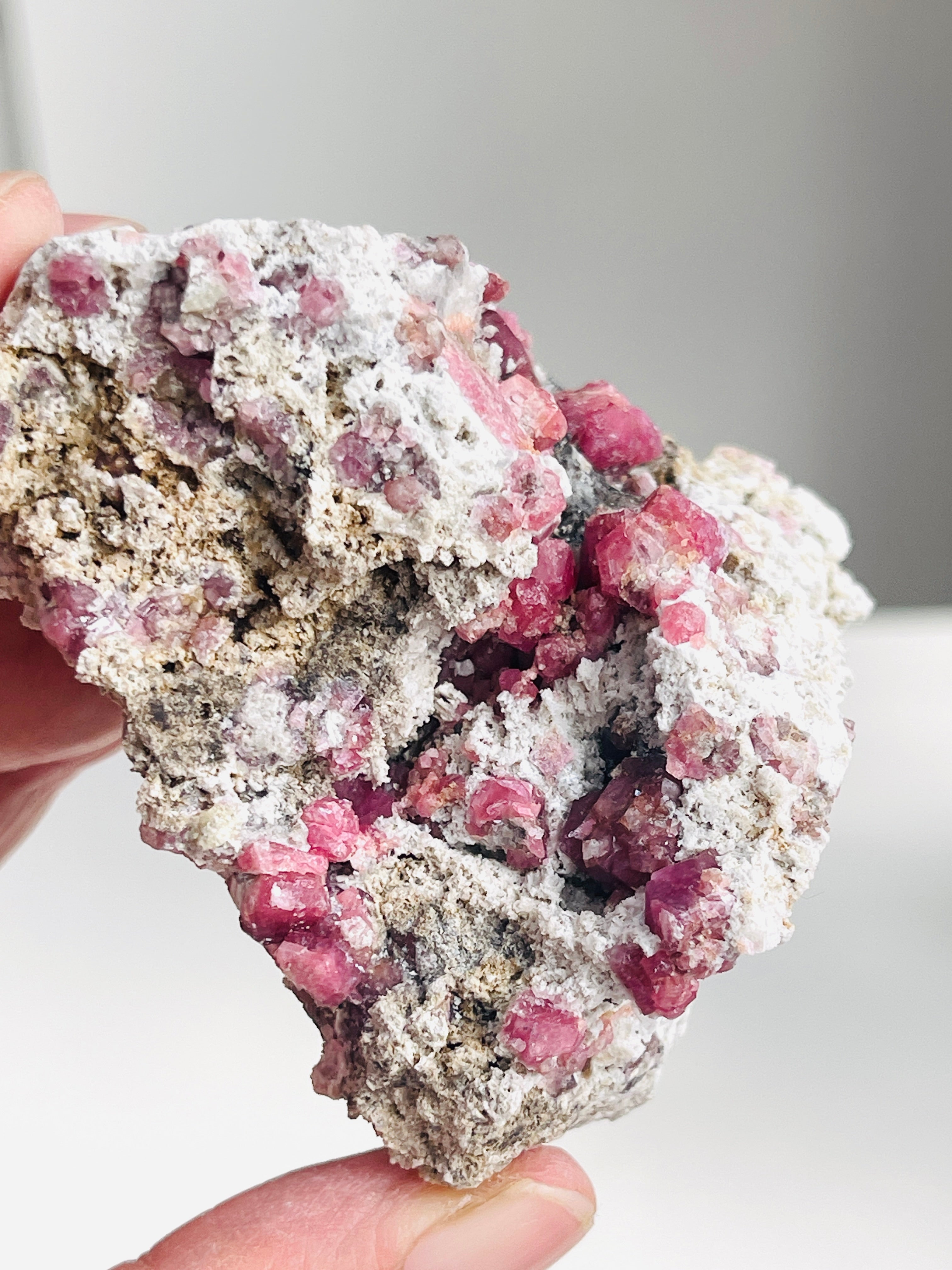 Mineral sample with pink crystals on a white background
