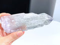 Hand holding a crystal with a blurred background